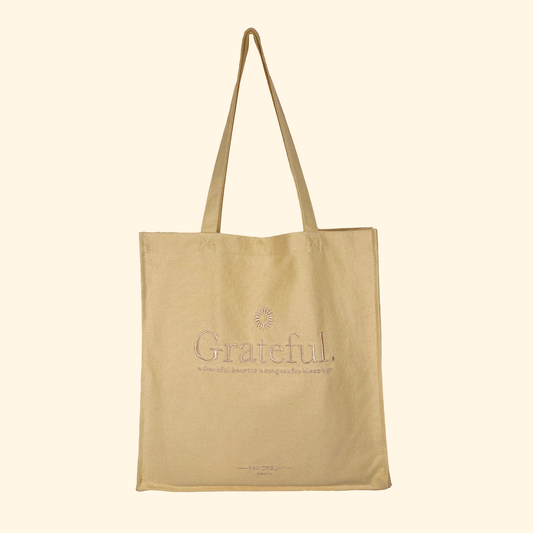 Beige yellow tote bag with embroidered design and long handles